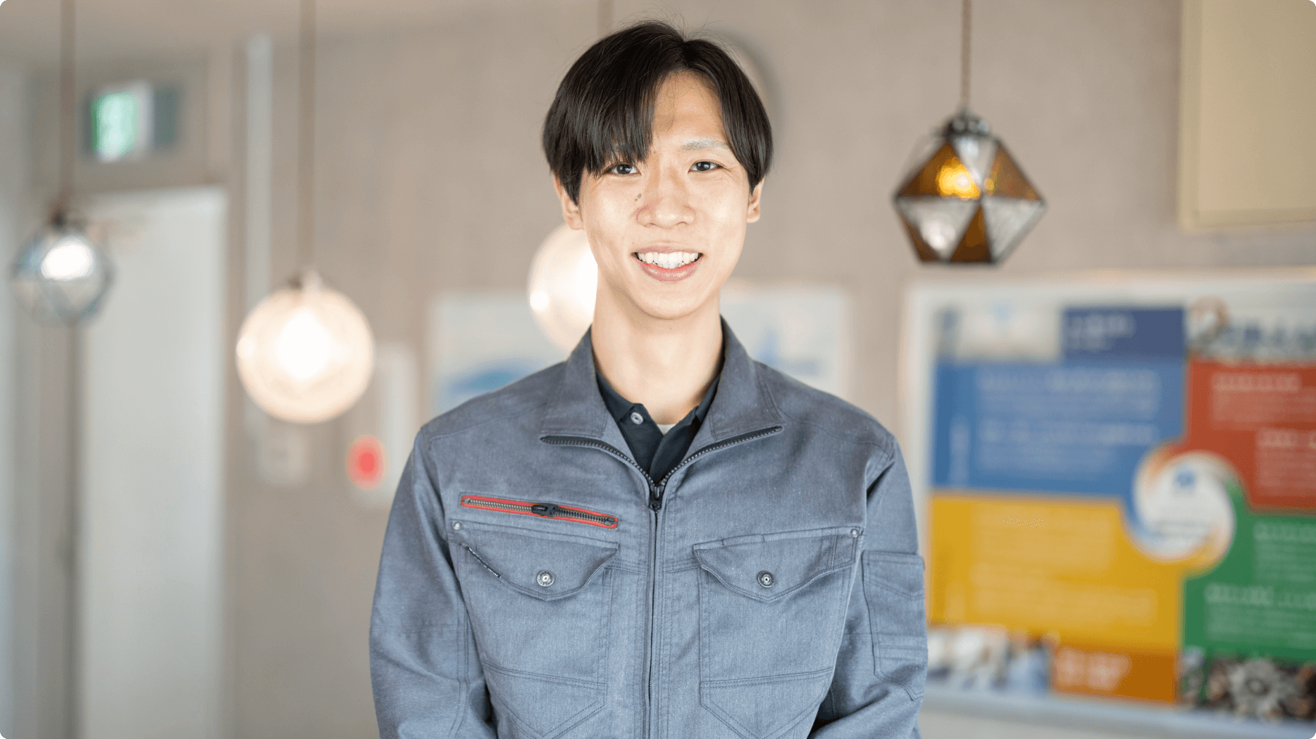 作業着を着用した、笑顔の鈴木一郎氏の写真