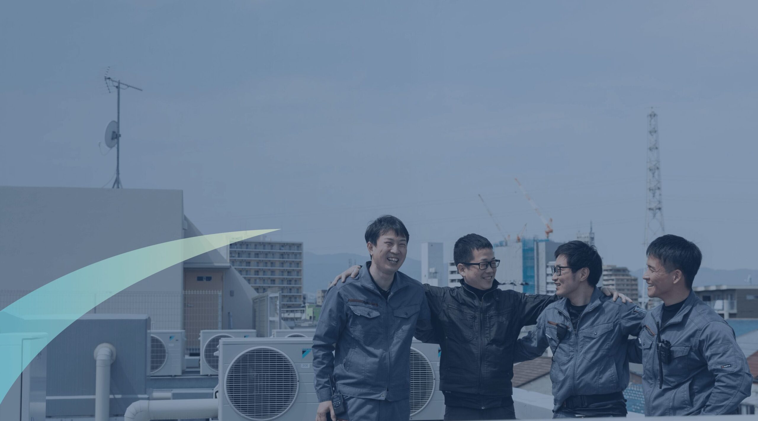 屋外で肩を組み、晴れやかな笑顔を見せるチームワーク抜群の4人の社員たち