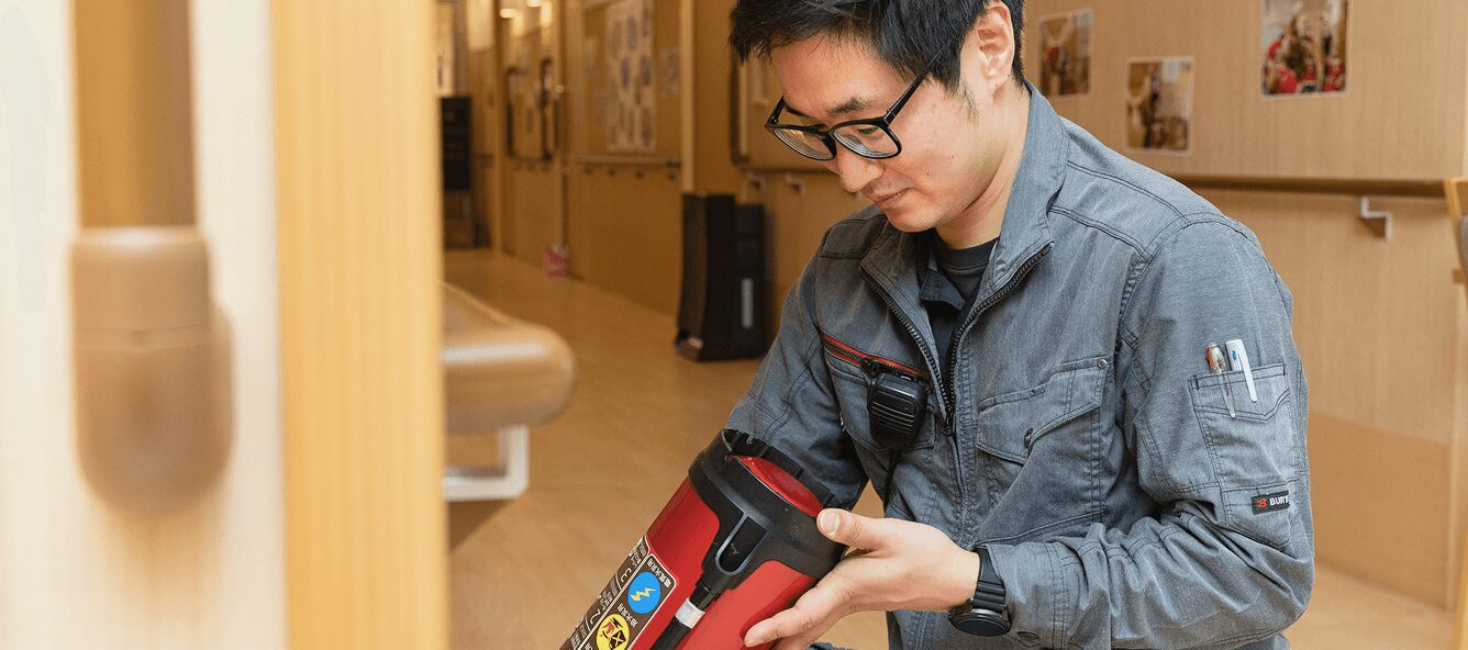 消火器の動作状況を一台ずつ入念に点検する技術スタッフ。火災から施設を守るための、妥協のない保守管理体制。