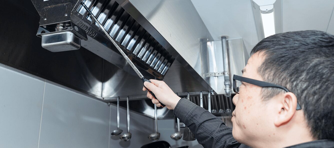 業務用キッチンの排気フード内部を専用器具で検査。火災リスクを最小限に抑えるための、徹底した衛生・安全管理。