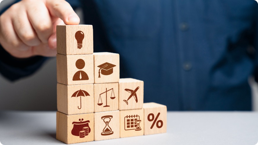 教育・成長・バランスを象徴するアイコンが描かれた積み木を積み上げる手元。着実なキャリア形成を支える充実した福利厚生制度。